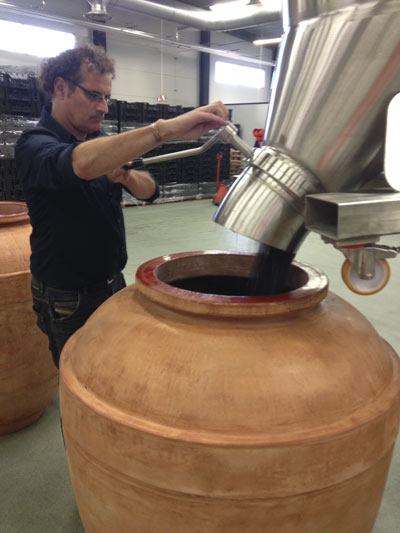 Filling an amphora with grapes