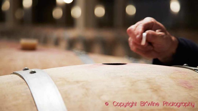 Adding a tablet of effervescent sulphur to a barrel of wine