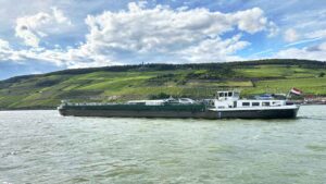 Vineyard landscape with with a barge on the Rhine river in Rheingau, Germany