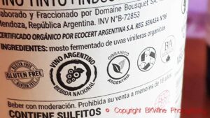 Back label on a wine bottle with certification stamps for gluten free, national drink, BDA sustainability, recycling, vegan, Ecocert and organics