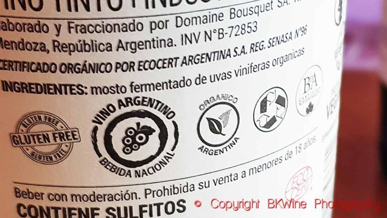 Back label on a wine bottle with certification stamps for gluten free, national drink, BDA sustainability, recycling, vegan, Ecocert and organics